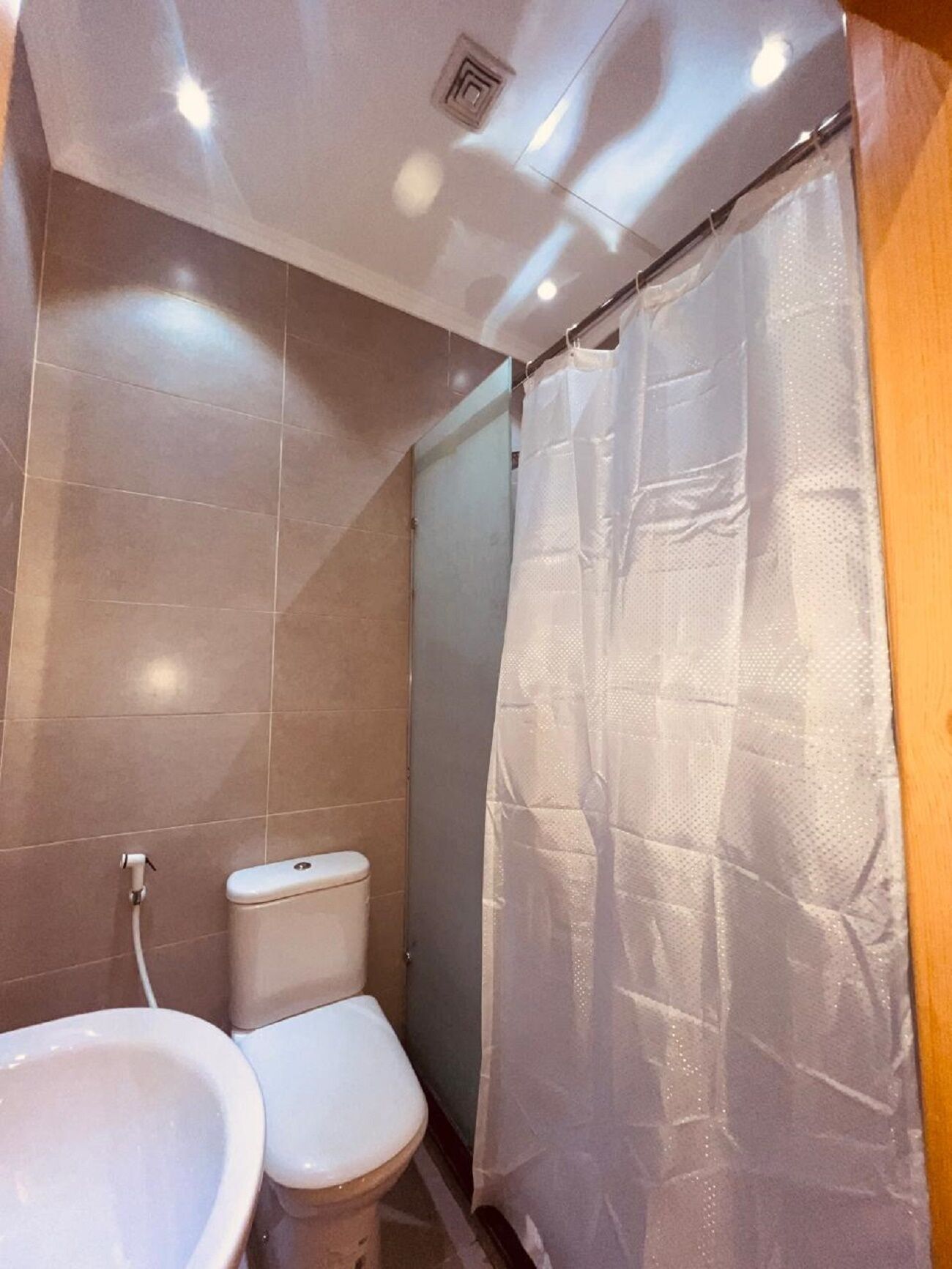 A bathroom with a toilet, sink, and shower curtain.