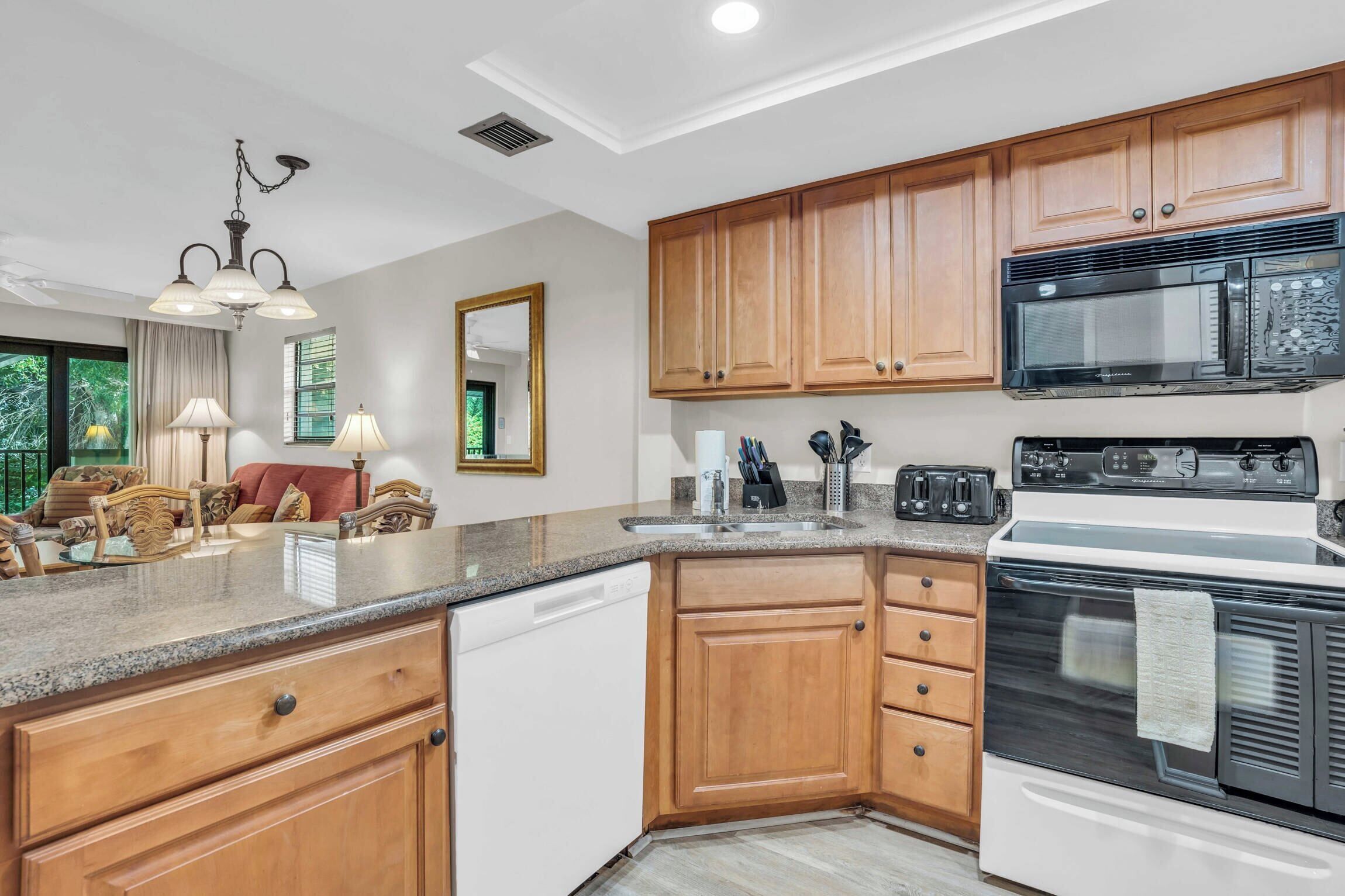 A kitchen with wooden cabinets, a microwave, a stove, and a dishwasher.
