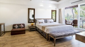 A spacious bedroom with a large bed, a wooden bench, a small table, and a chair. - Silver Oak Tropical Resort By Bay Hotels (Uran)