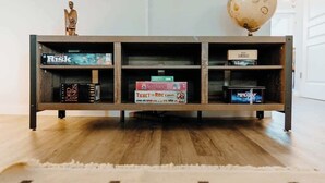 Ein Bücherregal aus Holz mit Büchern und einem Globus darauf.