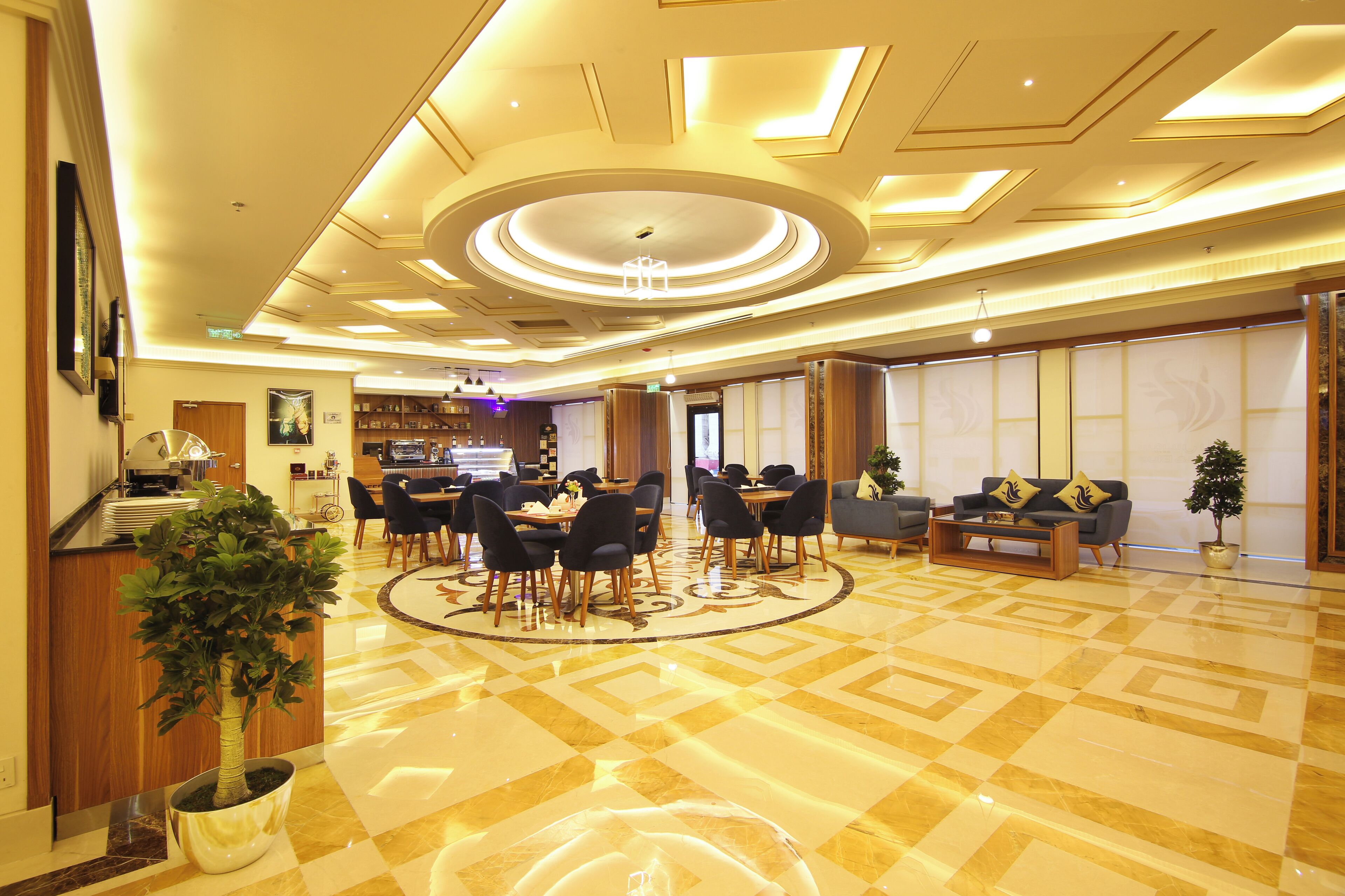 A spacious lobby with a central seating area, a reception desk, and a modern ceiling design.