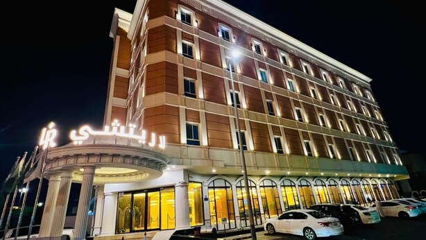 Un hotel de varios pisos con una entrada destacada y una fachada bien iluminada.