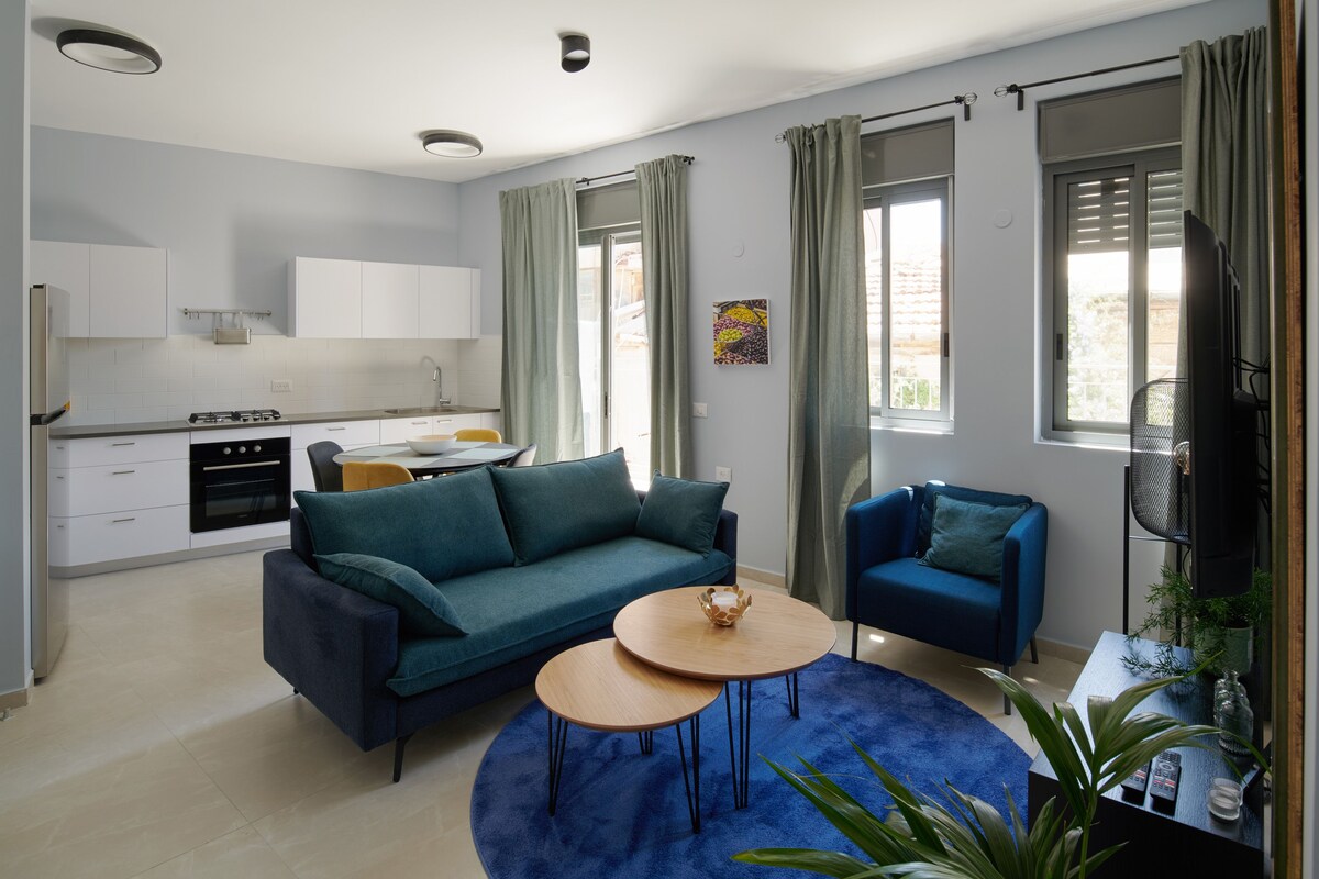 Een moderne woonkamer met een bank, twee bijzettafels en een televisie.