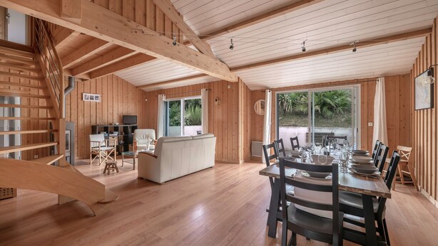 A spacious wooden interior with a dining area, kitchen, and a staircase. - House for 8 people - 300m from the beach (Saint-Michel-Chef-Chef)