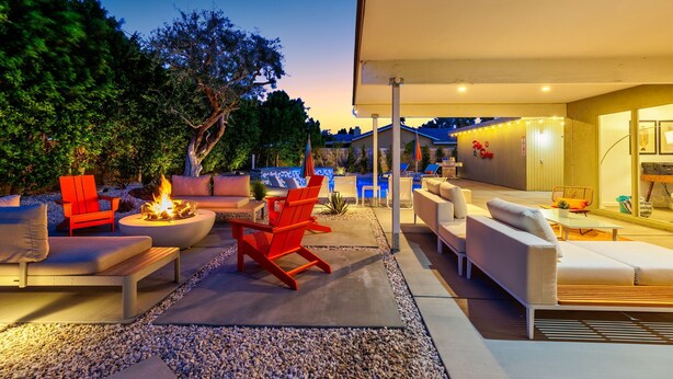 An outdoor patio area with modern furniture, a fire pit, and a pool in the background. - 30+ Stay! Perfect Family Getaway!  W/Pool, Jacuzzi & Fire Pit (Palm Springs)