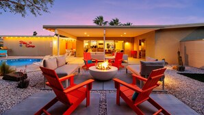 An outdoor patio with red chairs, a fire pit, and a pool. - 30+ Stay! Perfect Family Getaway!  W/Pool, Jacuzzi & Fire Pit (Palm Springs)