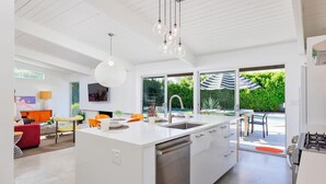 Una cocina moderna con una isla central, ventanas amplias y vistas al exterior.