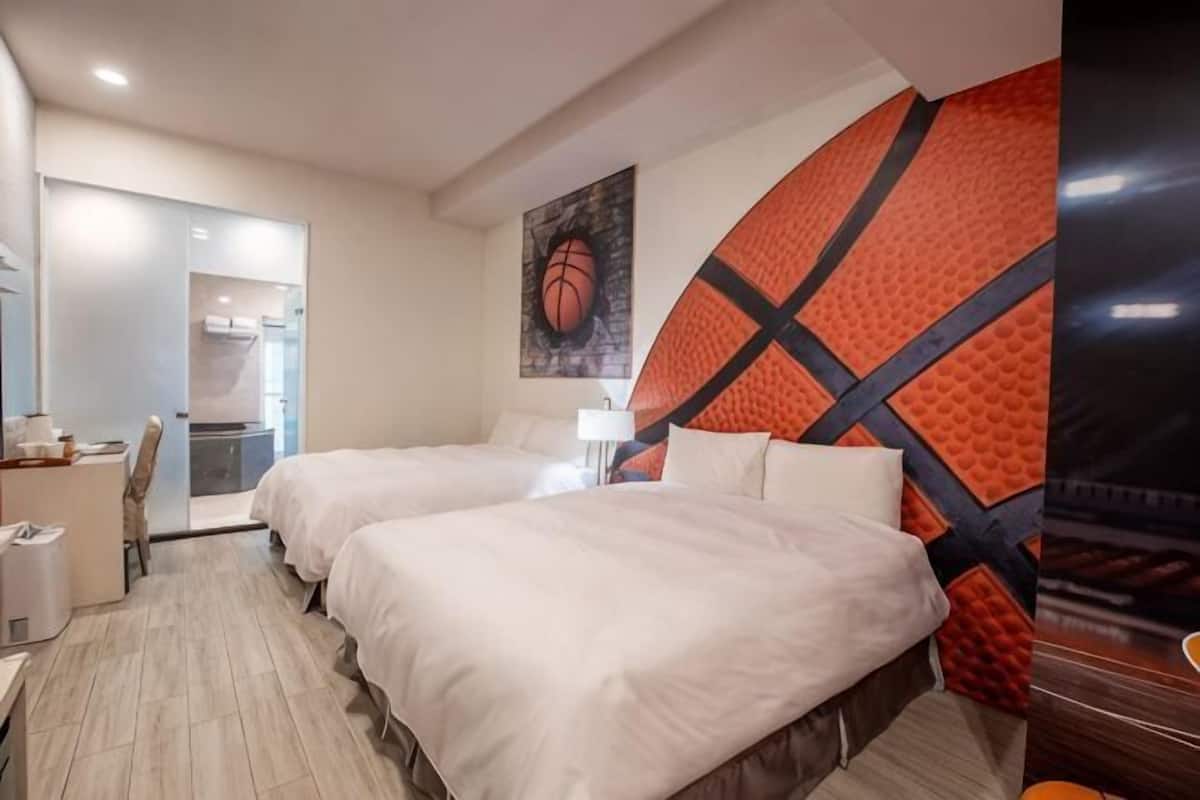 Une chambre d’hôtel avec deux lits, un bureau, une chaise et une grande fresque murale.