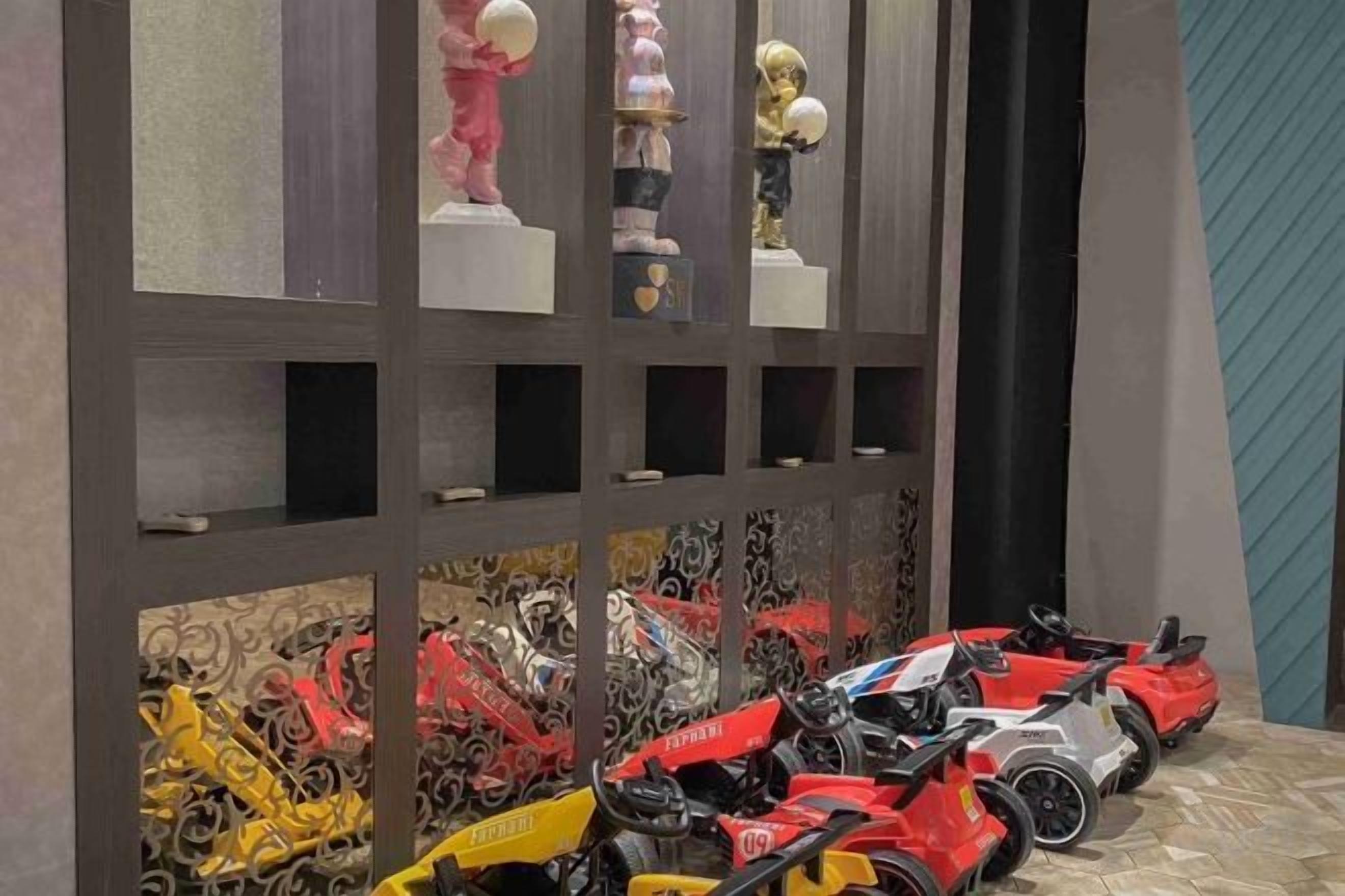 A display of model cars and figurines on shelves.