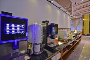 Una estación de café autoservicio con pantalla digital de menú y una máquina de café.