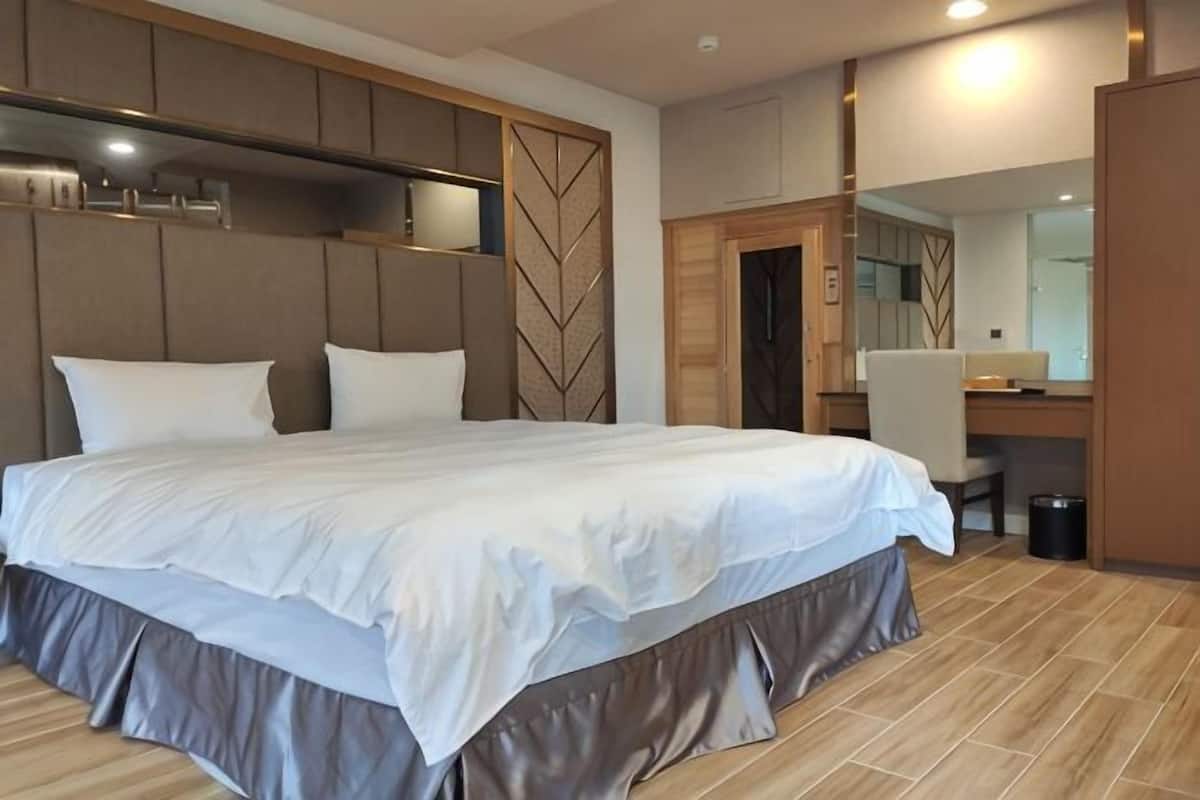 Une chambre d’hôtel moderne, dotée d’un grand lit, d’un bureau et d’un miroir.