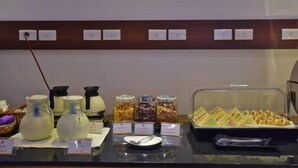 A buffet counter with various food items, including jars of pickled vegetables, a tray of sandwiches, and a pitcher of milk. - Muen Yuan Dong Hot Spring Hotel (Yilan)