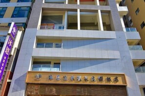 Un edificio de varios pisos con un letrero llamativo en la planta baja.