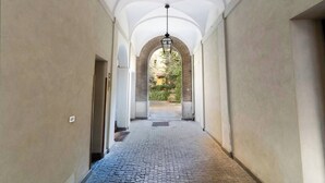 A corridor with arched ceilings and a hanging light fixture. - Quiet Trevi Fountain Apartment • Patio and Courtyard  (Roma)