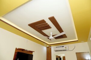 Una habitación con ventilador de techo, iluminación empotrada y aire acondicionado.