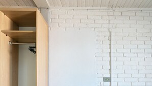 Une cuisine moderne avec des étagères en bois, un plan de travail et deux tabourets.