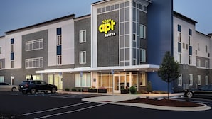 Un hotel moderno con un cartel que dice "apt suites" y un estacionamiento con coches.