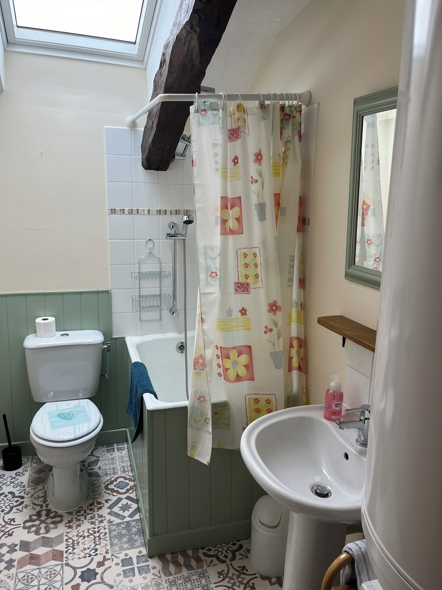A bathroom with a shower, toilet, and sink.