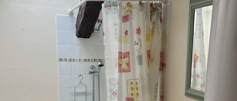 A bathroom with a shower, toilet, and sink.