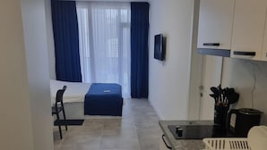 A modern kitchen with a built-in stove, a sink, and a countertop. There is a dining area with a table and chairs.