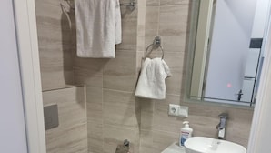 A modern bathroom with a toilet, sink, and shower.
