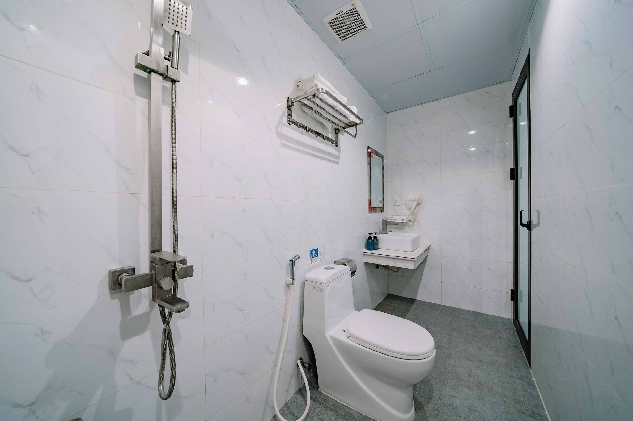 A modern bathroom with a shower, toilet, and sink.
