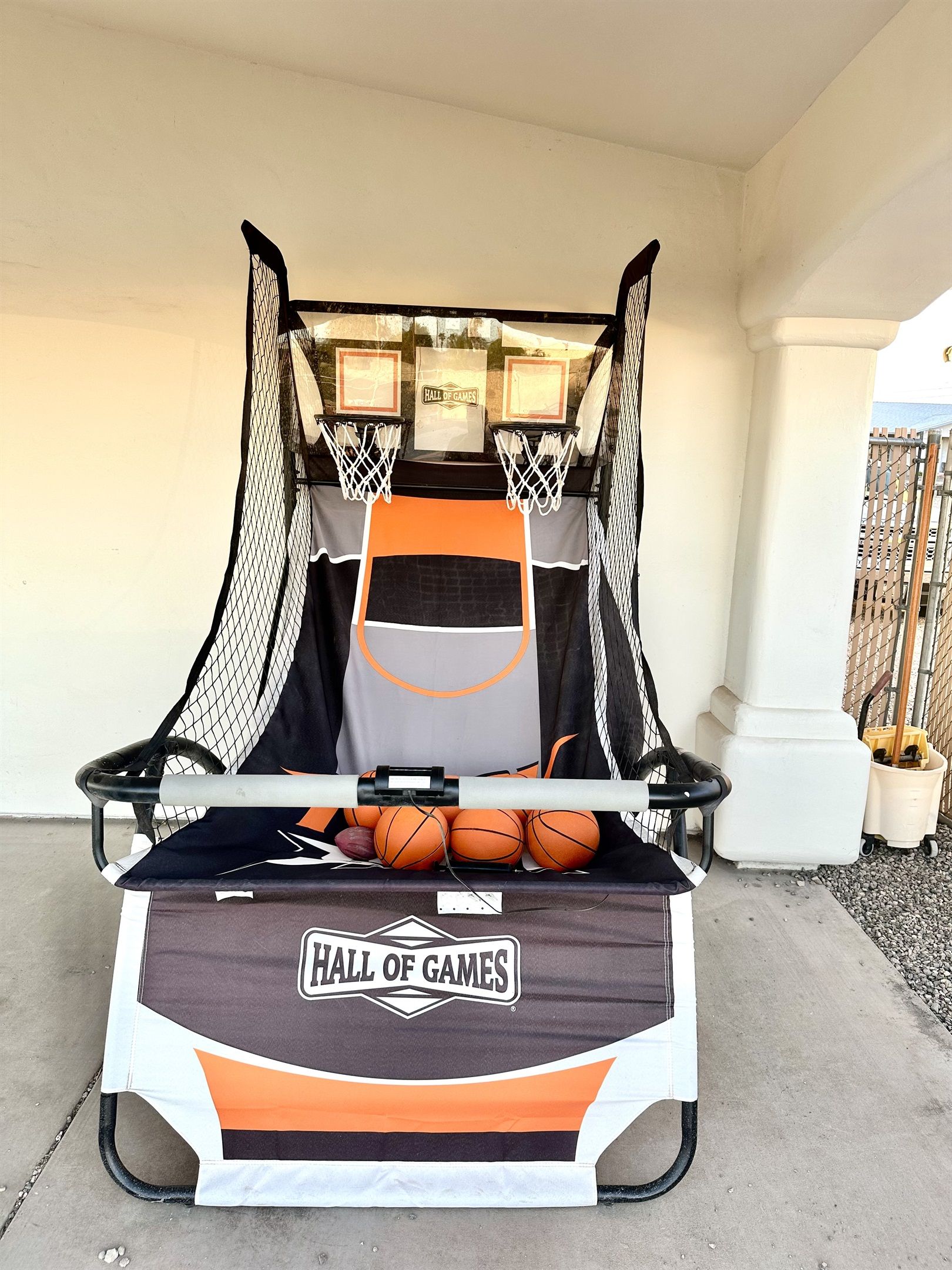 A basketball hoop with a net, a backboard, and a "Hall of Games" banner.