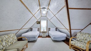 A triangular attic bedroom with two single beds, a sofa, and a chair. - Pondside Retreat Near Narrowsburg & The Delaware River (Beach Lake)