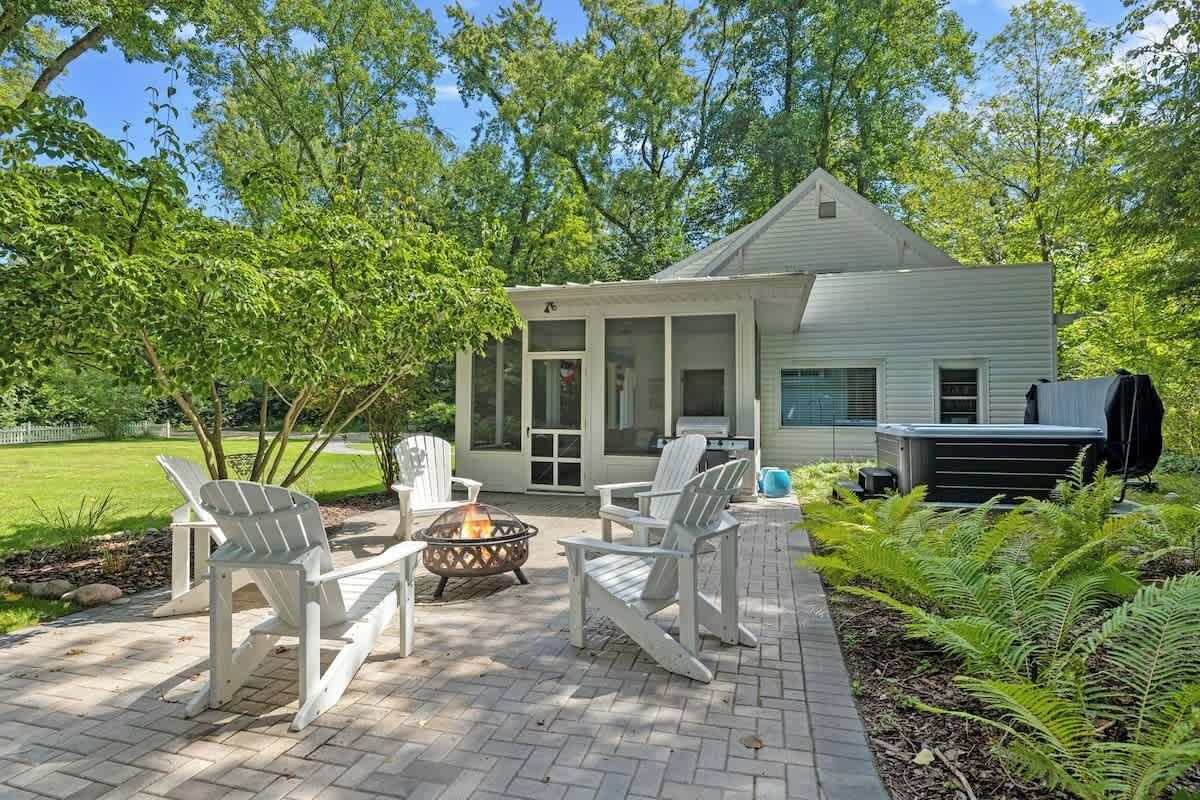 A house with a covered patio, outdoor seating, and a fire pit.