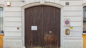Una puerta de madera grande y arqueada con un cartel que indica que hay una oferta.