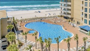 A hotel with a pool surrounded by palm trees, a beach, and ocean views. - *Oct 10 - 18th Getaway! * Beach Chairs! (Panama City Beach)