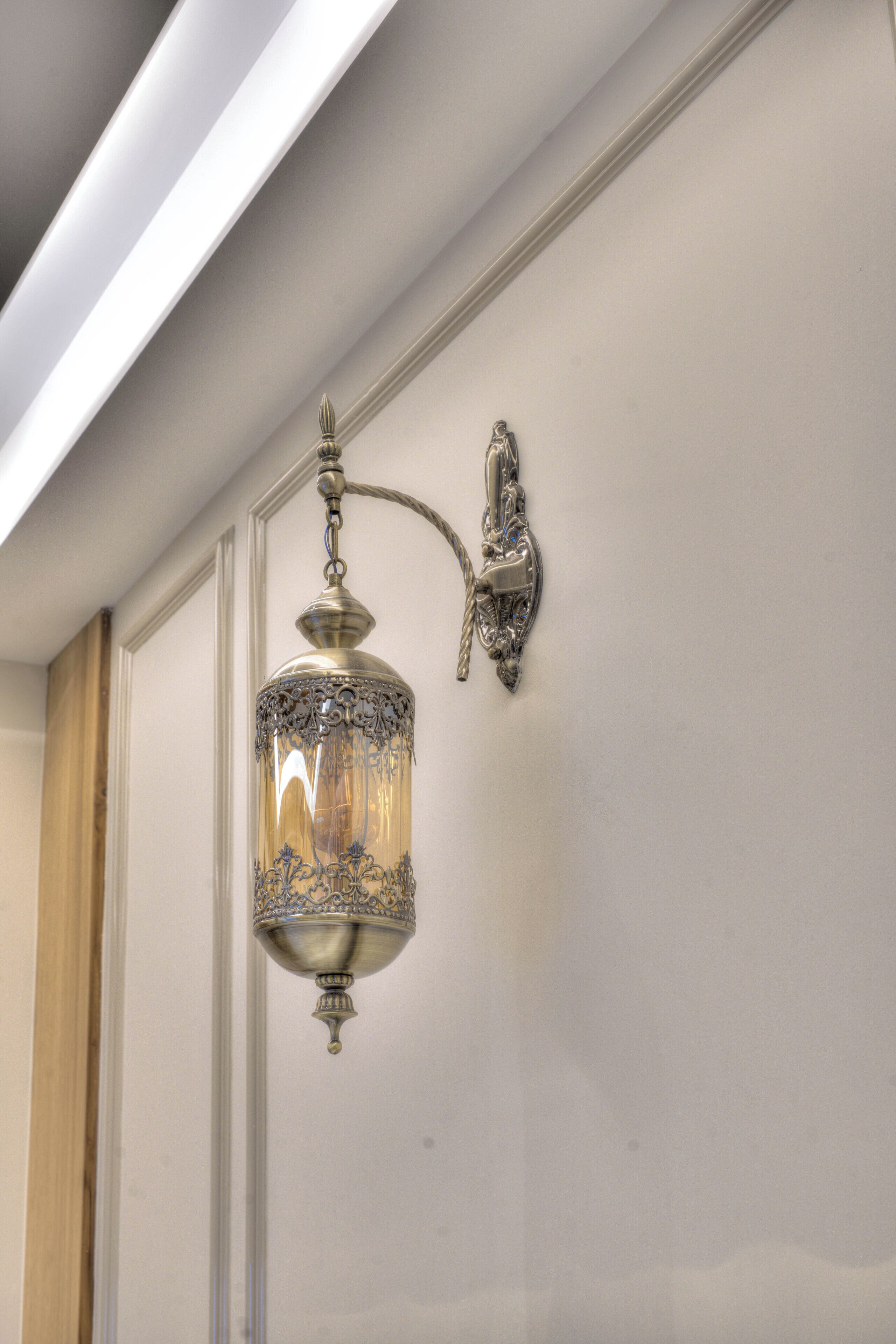 A wall-mounted light fixture with intricate metalwork.