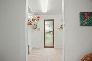 Un pasillo con un armario, una puerta y un cuadro en la pared.
