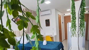 A hotel room with two beds, a desk, and a mirror. - Villas do Porto - 109 by La Playa (Ipojuca)