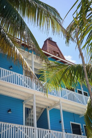 A two-story building with a blue exterior and white railings.
