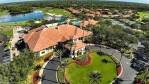 Um resort com um edifício grande, um lago e vegetação ao redor.