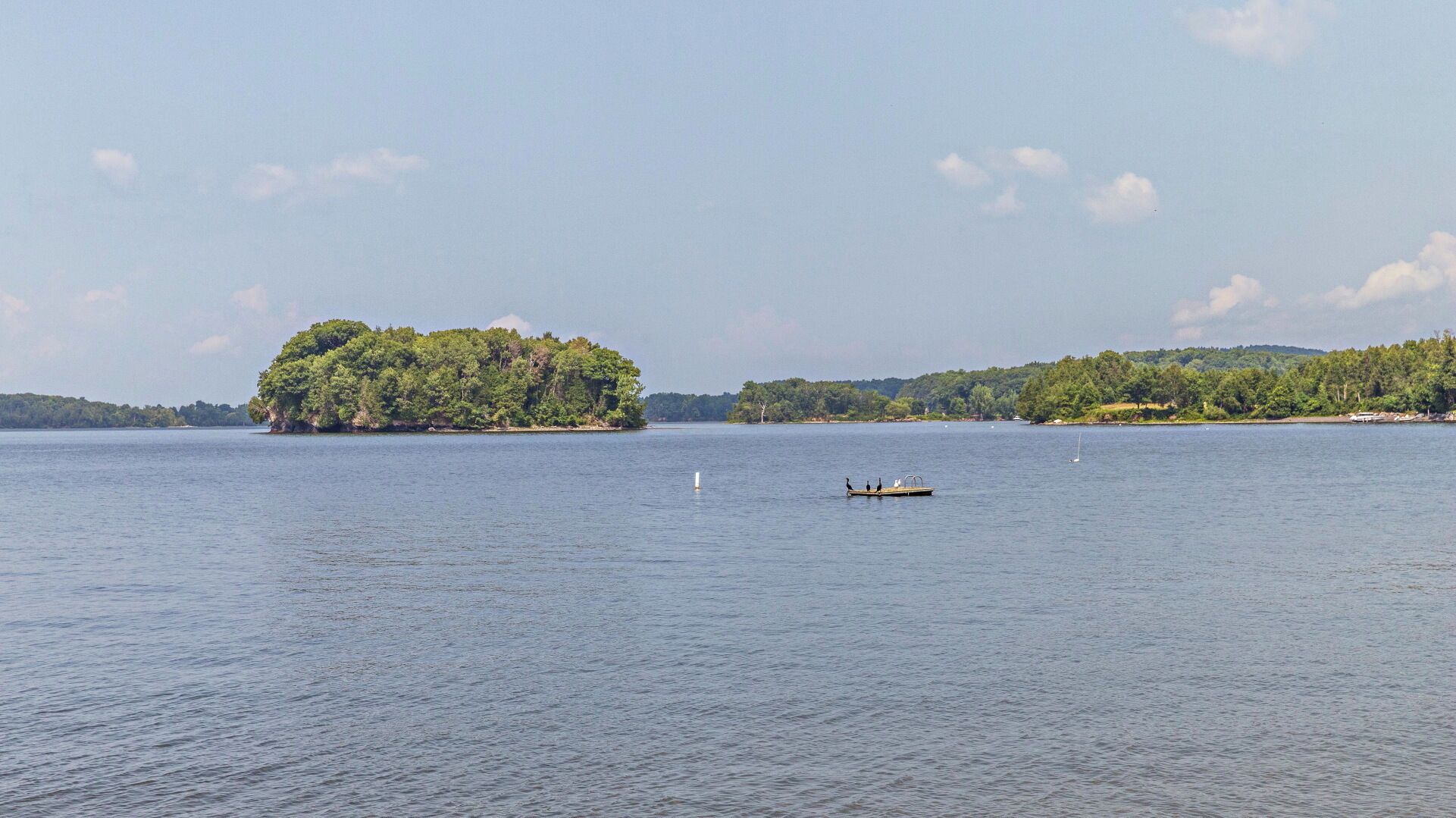 Un lago tranquilo con una pequeña isla cubierta de árboles.