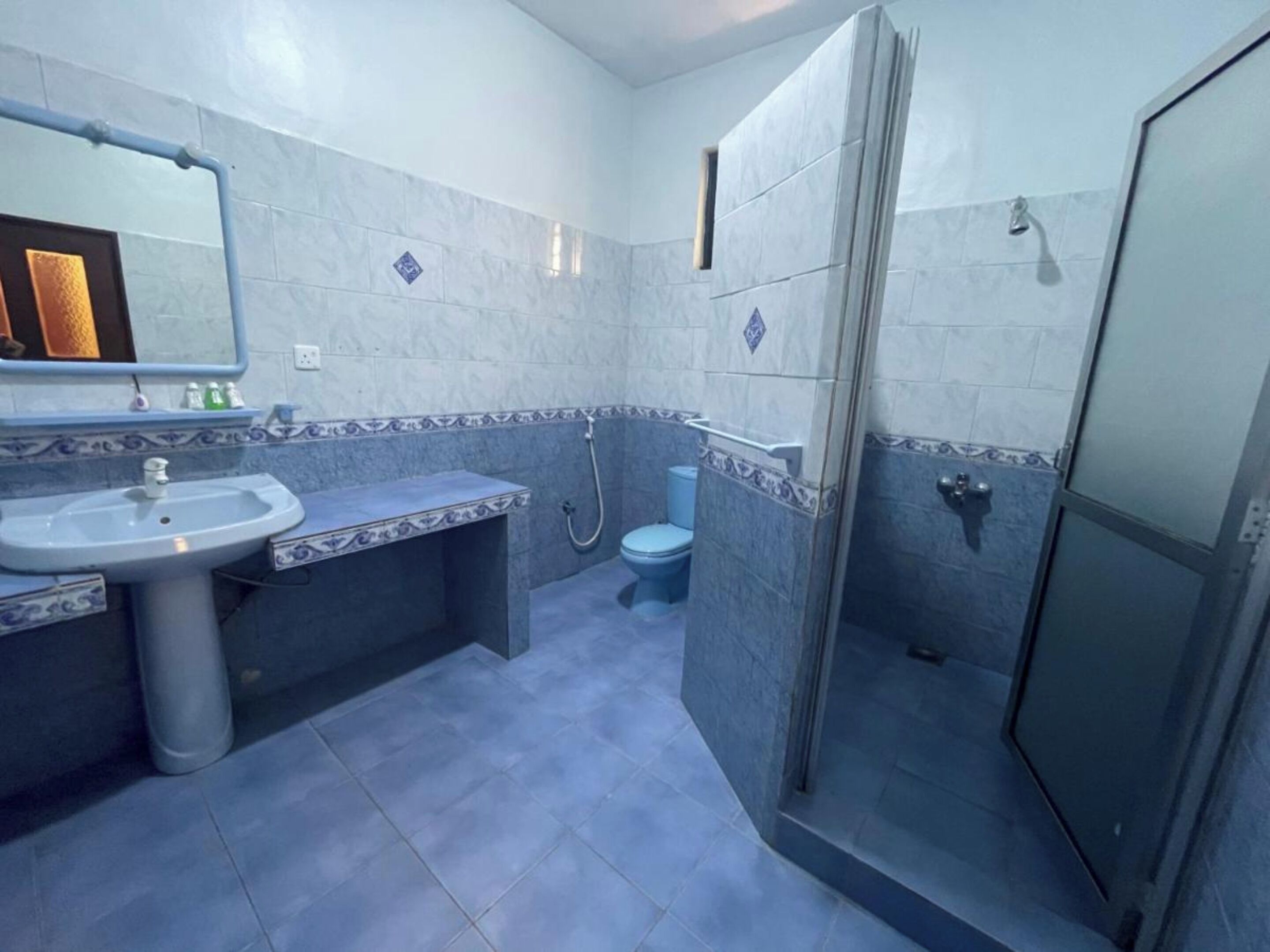 A bathroom with a sink, toilet, and shower.