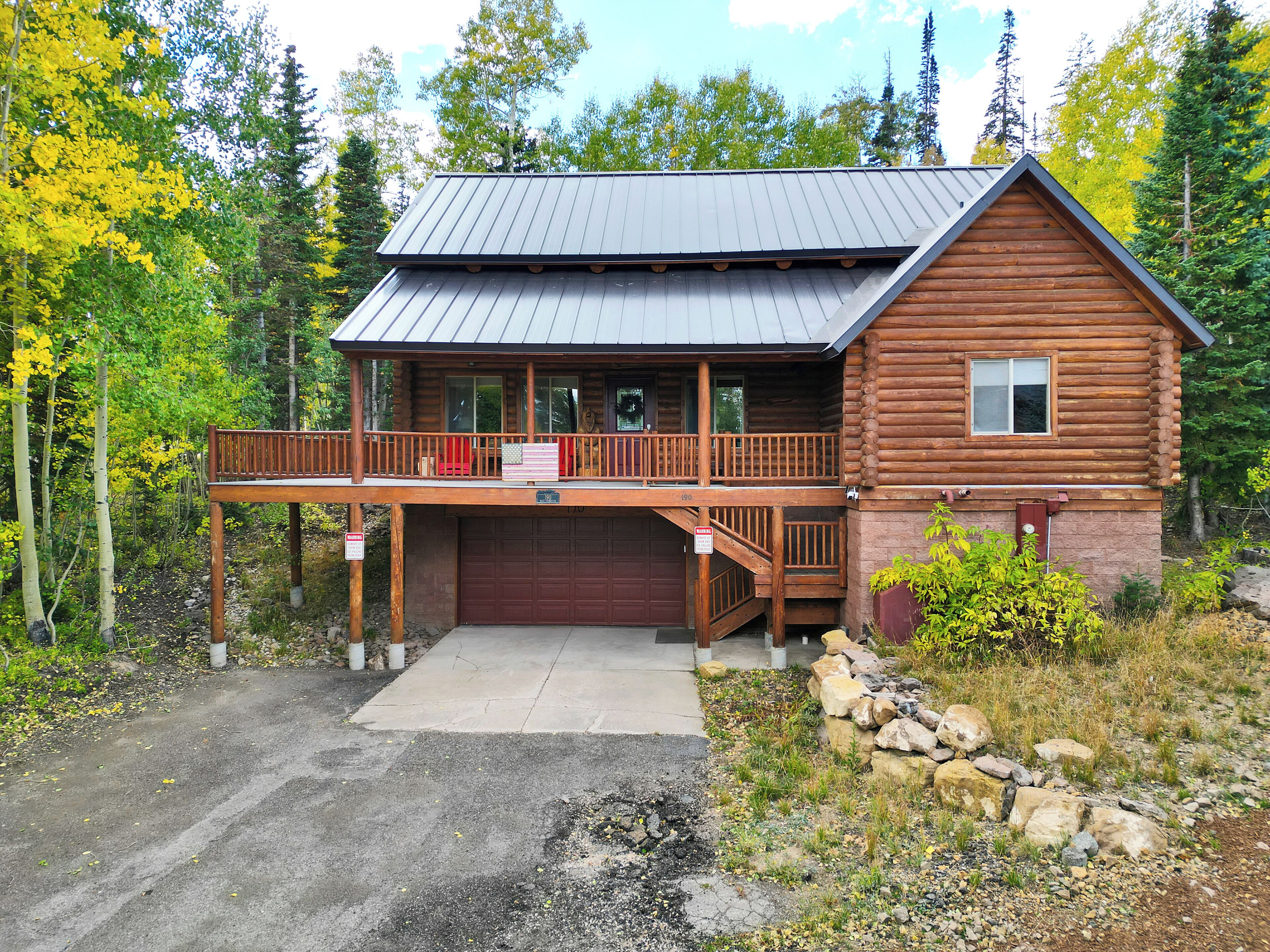 A log cabin with a covered porch and a garage.