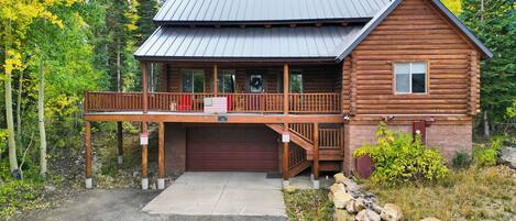 A log cabin with a covered porch and a garage.