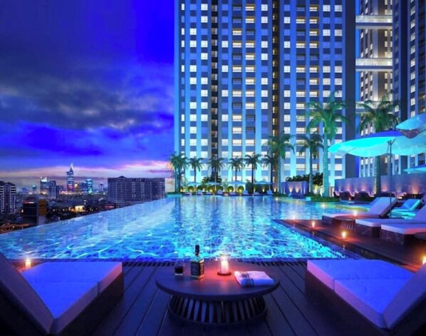 Relax by the pool surrounded by lounge chairs and umbrellas.