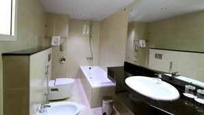 Uma casa de banho moderna com banheira, sanita e lavatório.