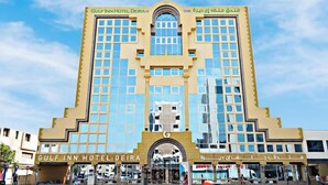 Um hotel com fachada simétrica, janelas amplas e entrada central.