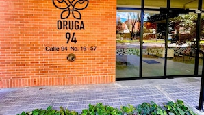 A brick building with a sign reading "ORUGA 94 Calle 94 No. 16-57". - Bright Studio with Balcony 615 (Bogotá)