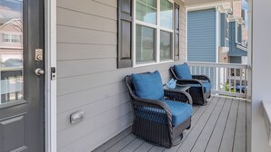 A porch with wicker chairs and a door. - Luxury 5BR Ideal For Vacationers, Groups, Corporate & Insurance Stays Near ATL (Fairburn)