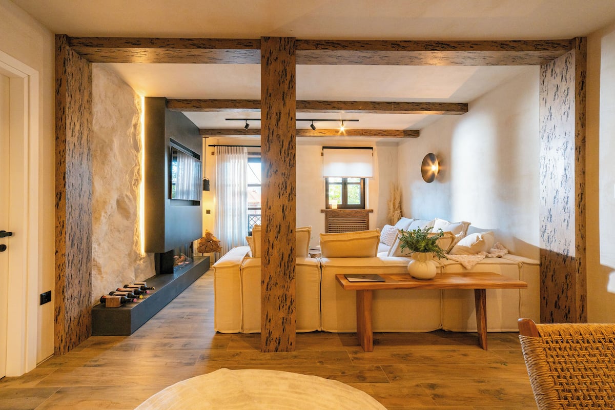 Un salon chaleureux avec un canapé, une table en bois et un fauteuil en osier.