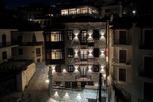 Un edificio de varios pisos con balcones y un área de piscina, rodeado de otros edificios.