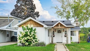A single-story house with a front porch, a chimney, and a large tree in the background. - Family-friendly Retreat on Gilletts Lake! (Jackson)