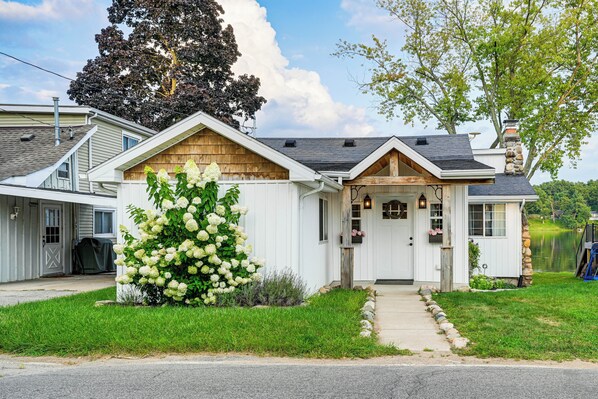 A single-story house with a front porch, a chimney, and a large tree in the background. - Family-friendly Retreat on Gilletts Lake! (Jackson)