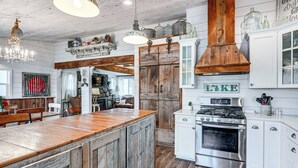 A rustic kitchen with a wooden island, white cabinetry, and a stainless steel stove. - Family-friendly Retreat on Gilletts Lake! (Jackson)